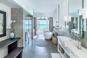 A modern bathroom with a large bathtub, a walk-in shower, and a vanity with a mirror.