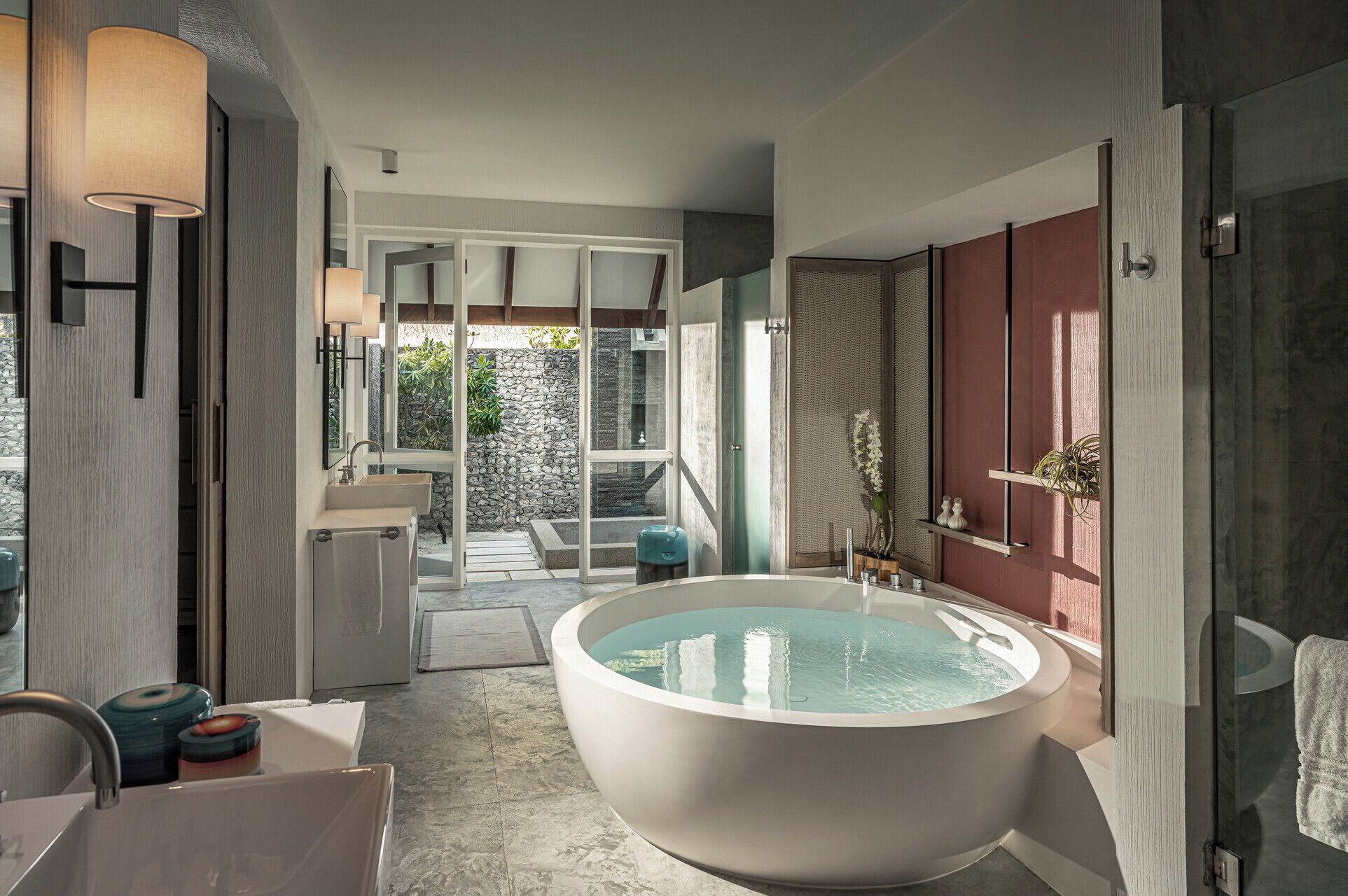 A modern bathroom with a large bathtub, a sink, and a shower area.