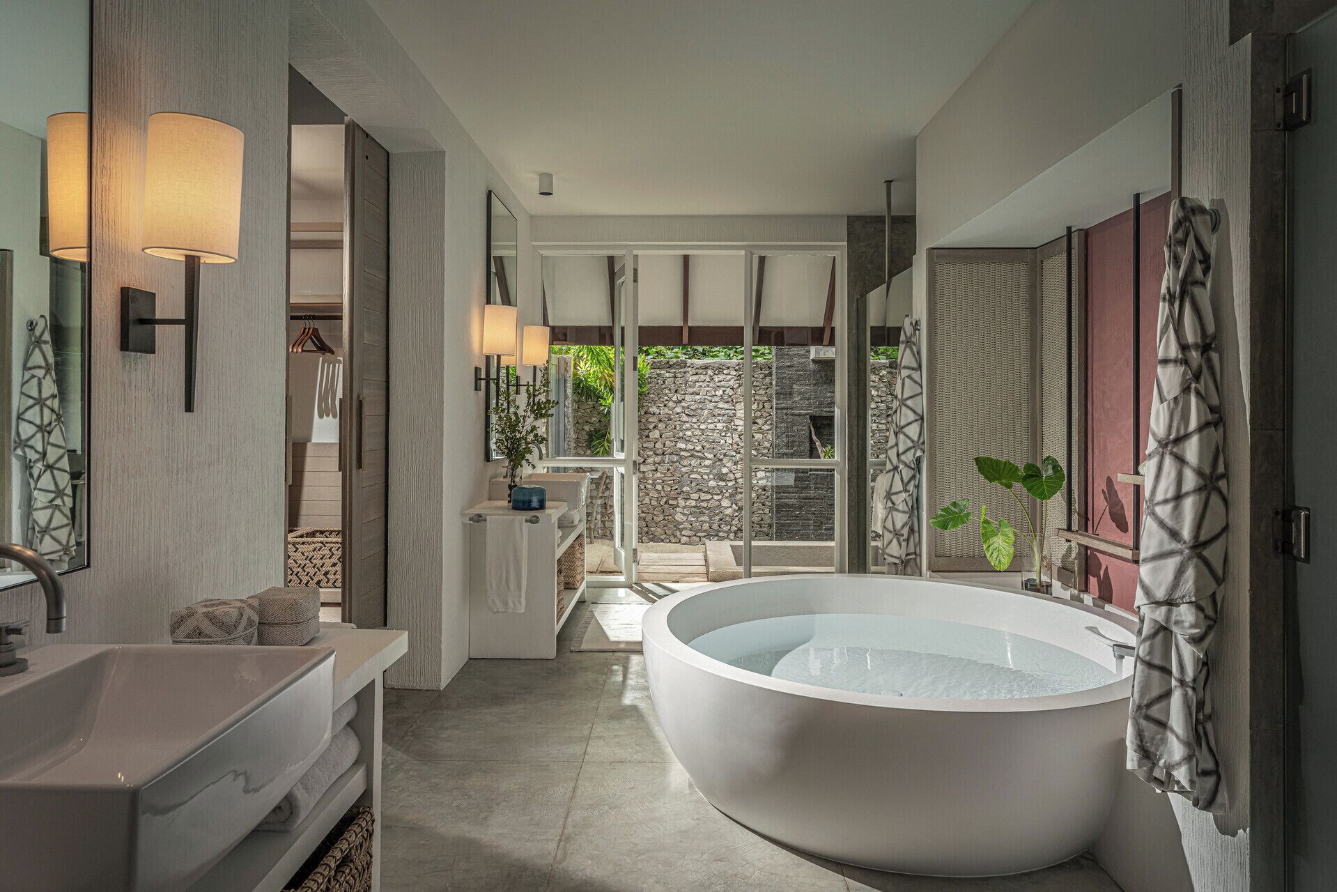 A modern bathroom with a freestanding bathtub, a vanity with a mirror, and a shower area.