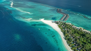 An aerial view of a resort with overwater bungalows, a sandy beach, and clear turquoise waters. - Four Seasons Maldives at Landaa Giraavaru (Landaa Giraavaru)
