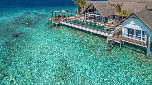 An overwater bungalow with a thatched roof, a private pool, and a wooden deck. - Four Seasons Maldives at Landaa Giraavaru (Landaa Giraavaru)
