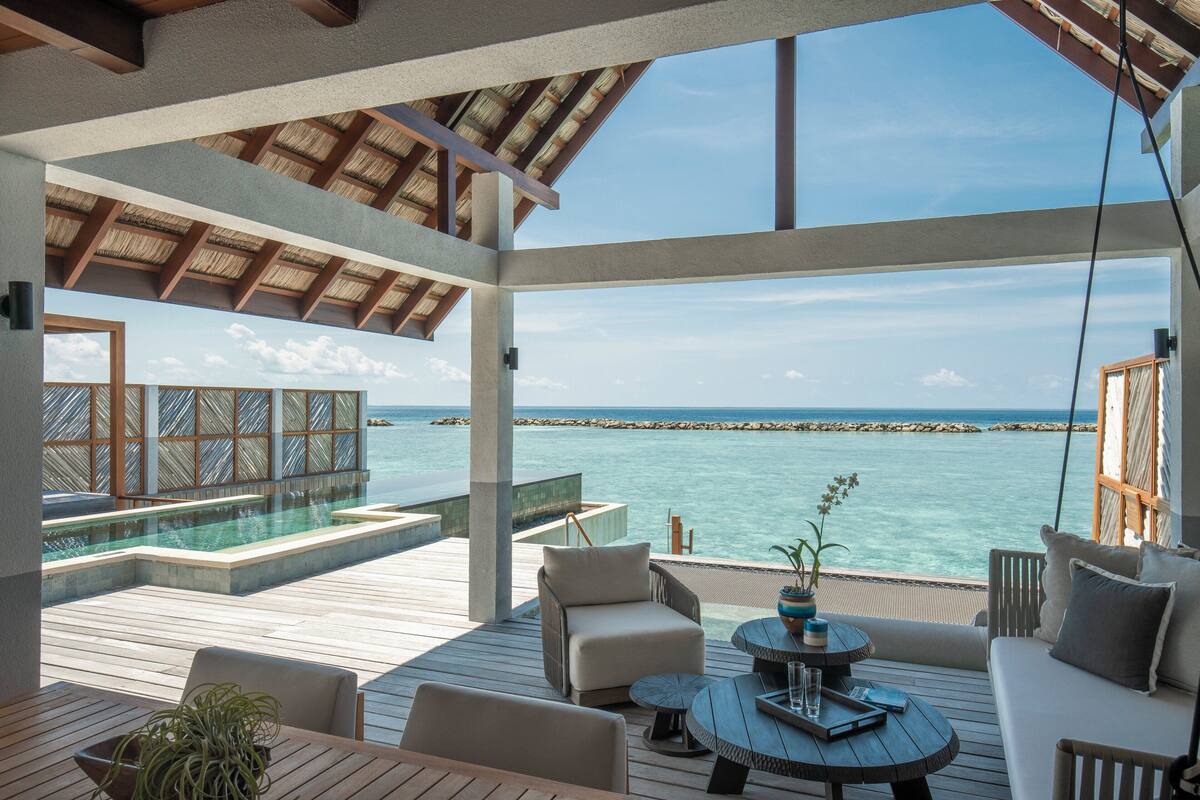 Ein großzügiger Außenbereich mit Pool, Sitzgelegenheiten und Meerblick.