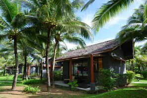 A resort with multiple bungalow-style accommodations, surrounded by lush greenery and palm trees.