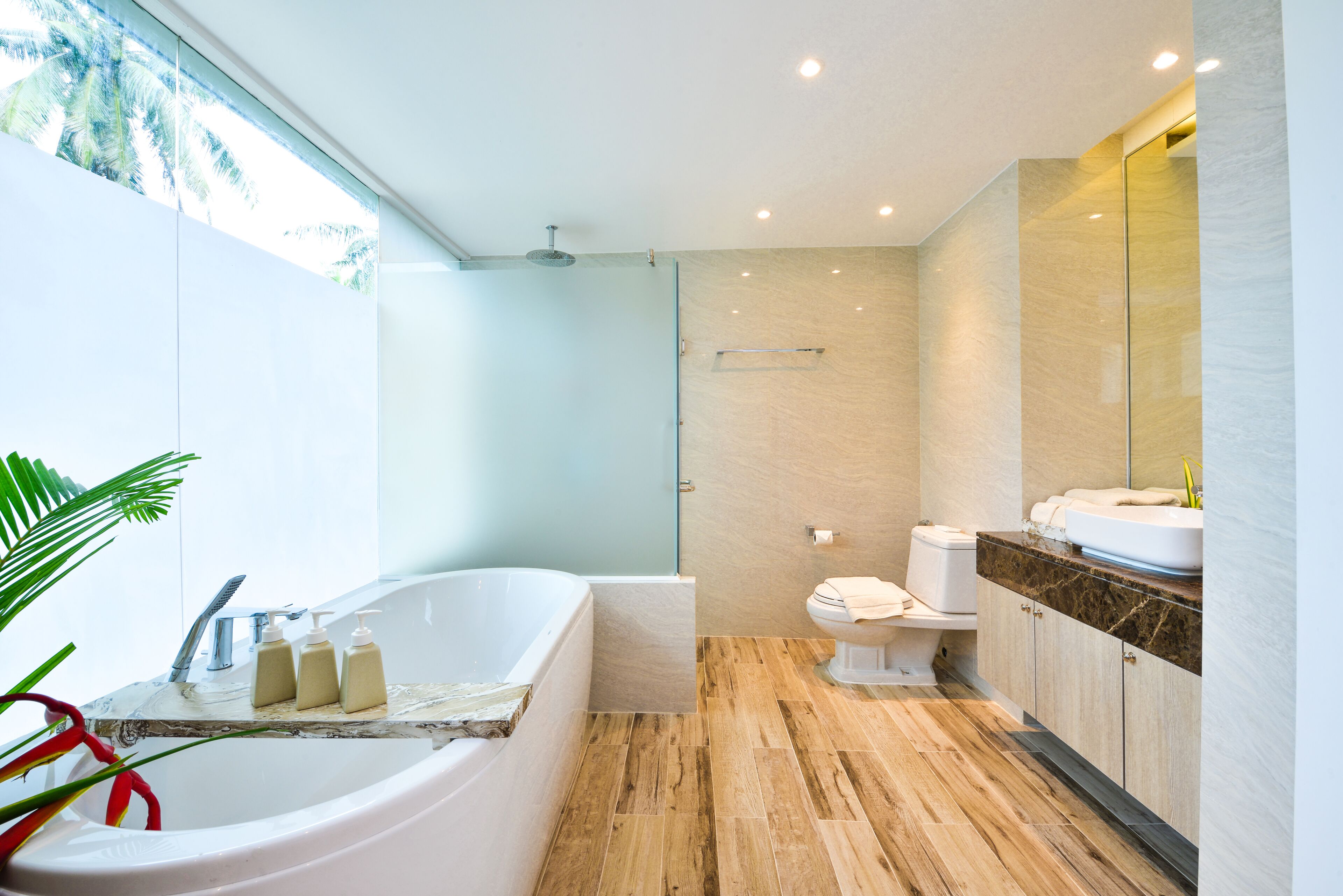 A modern bathroom with a bathtub, toilet, and vanity.