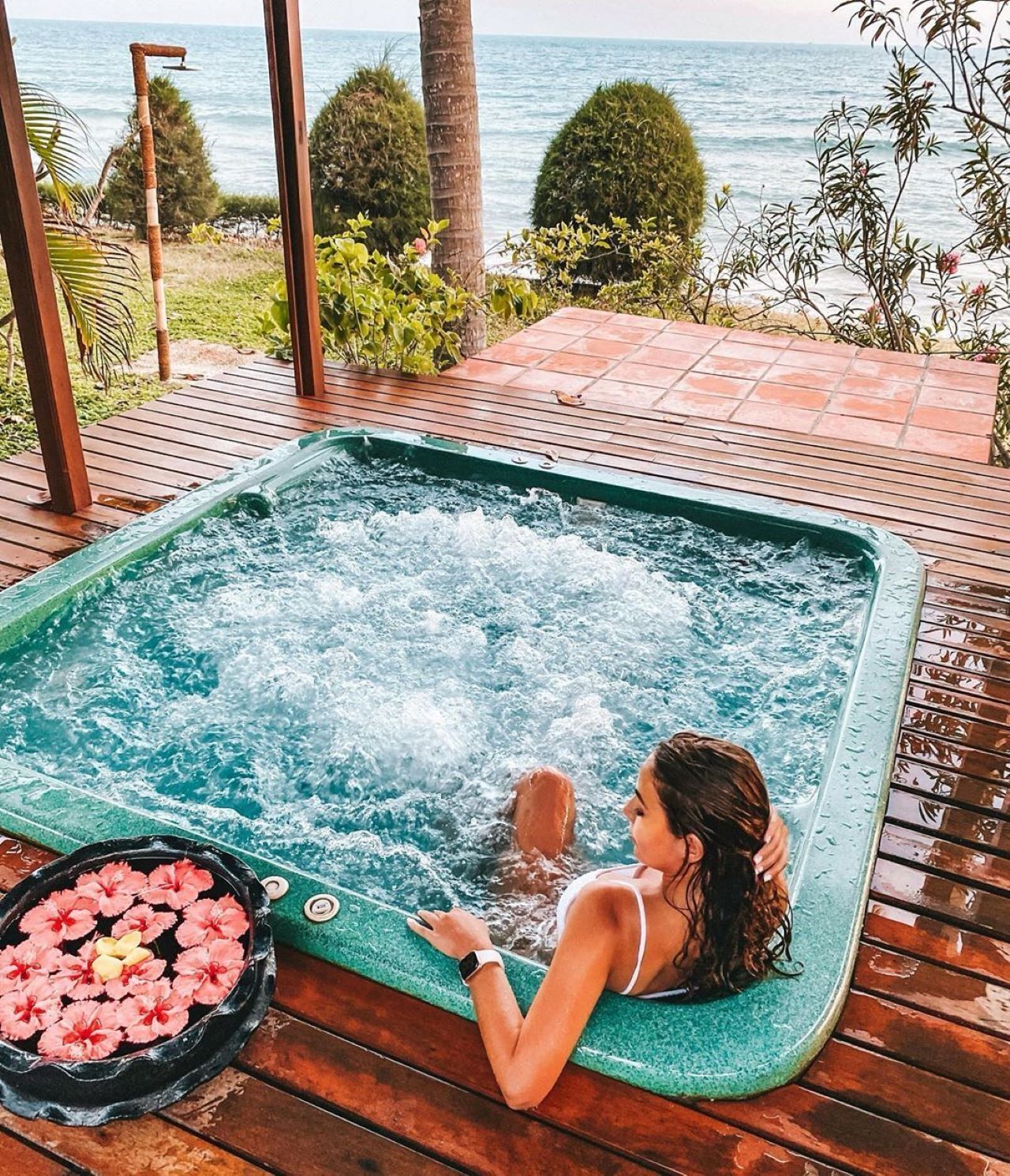 Una persona relajándose en un jacuzzi con vista al mar.