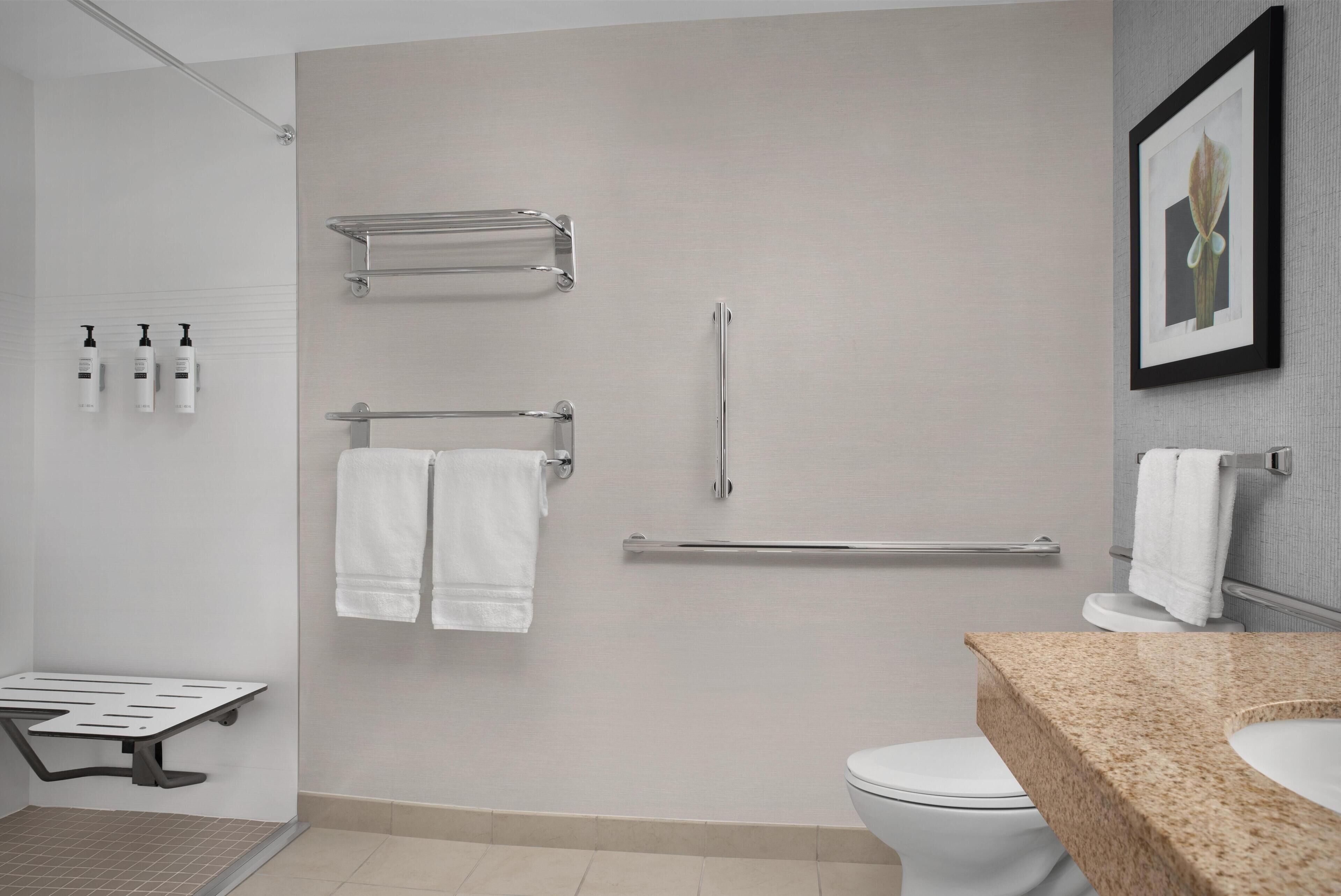 A modern bathroom with a shower, toilet, and sink.