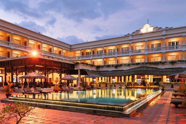 Una piscina al aire libre, sombrillas, sillones reclinables de piscina