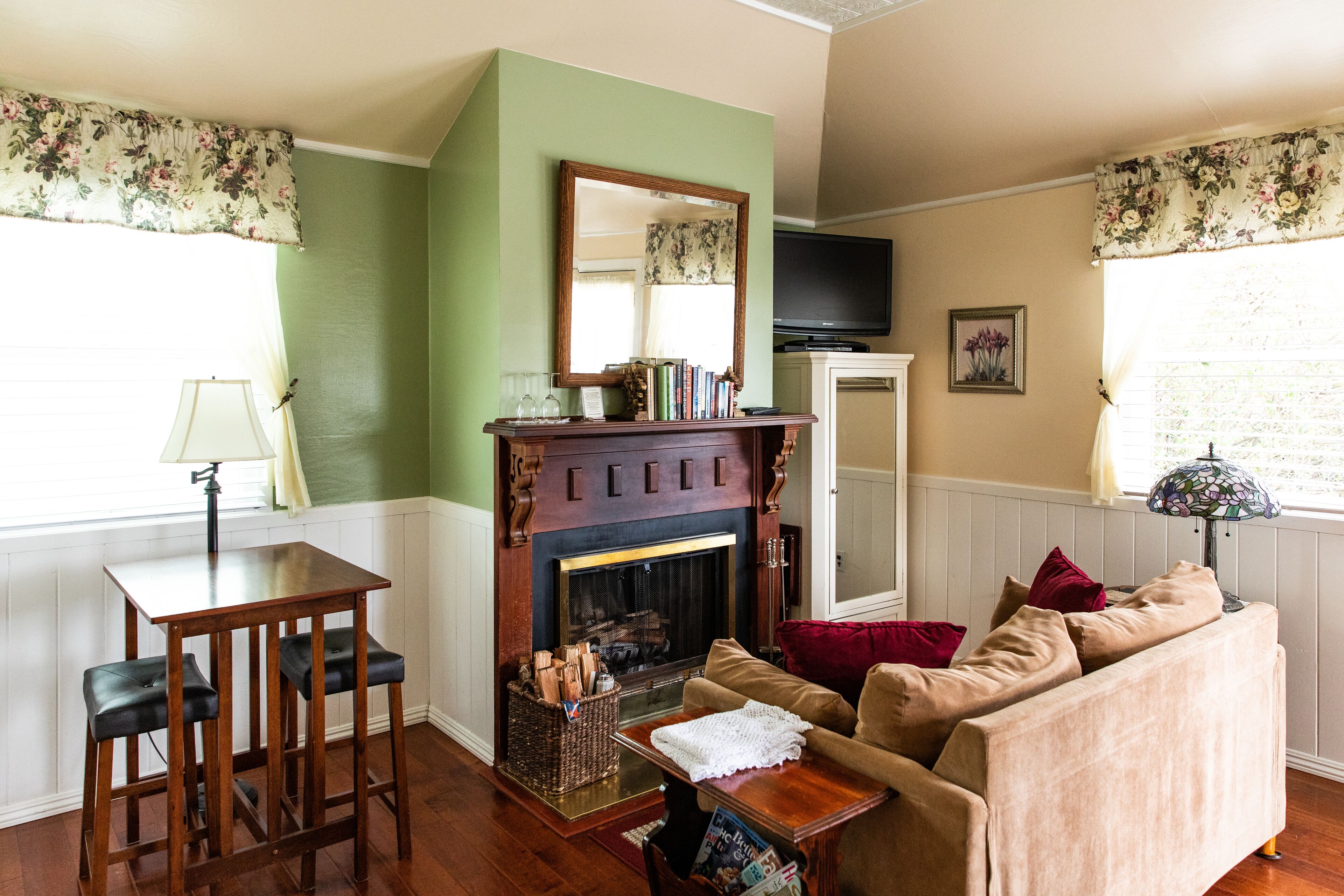Una sala de estar acogedora con chimenea, un sofá, una mesa de centro y un televisor.