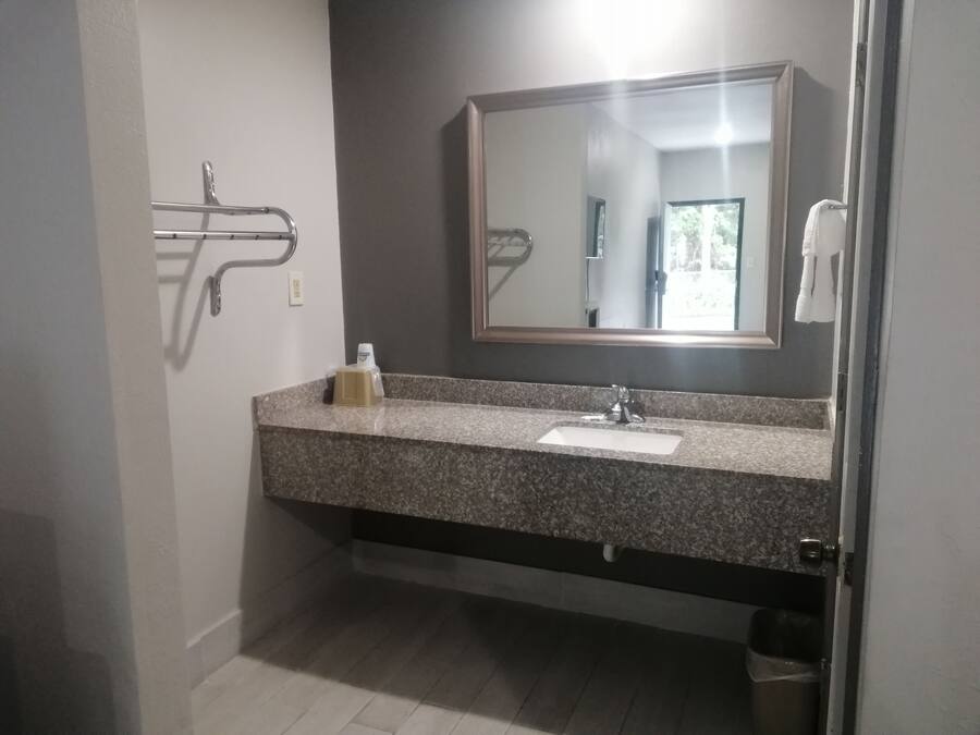 Un bagno con lavabo in granito, uno specchio, un portasciugamani e un asciugamani ad aria.