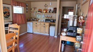 A compact kitchen with wooden cabinets, a microwave, and a coffee machine.