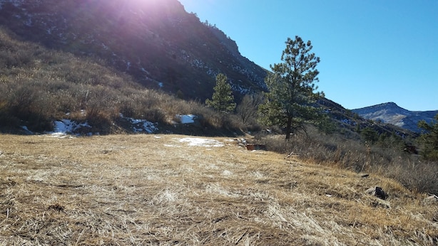 A mountainous landscape with dry grass, a few trees, and patches of snow on the slopes. - Stone Mountain Lodge and Cabins (Lyons)