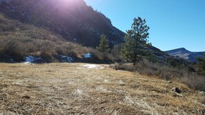 A mountainous landscape with dry grass, a few trees, and patches of snow on the slopes. - Stone Mountain Lodge and Cabins (Lyons)