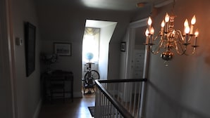 A staircase with a chandelier, a globe, and a bicycle in the background. - Magnolia Manor B&B Inn (Williamsburg)