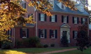 A large brick building with a central entrance, multiple windows, and a well-maintained lawn. - Magnolia Manor B&B Inn (Williamsburg)