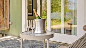 A table with a bottle of champagne and two glasses on a balcony. - Bodega Bay Inn (Bodega Bay)