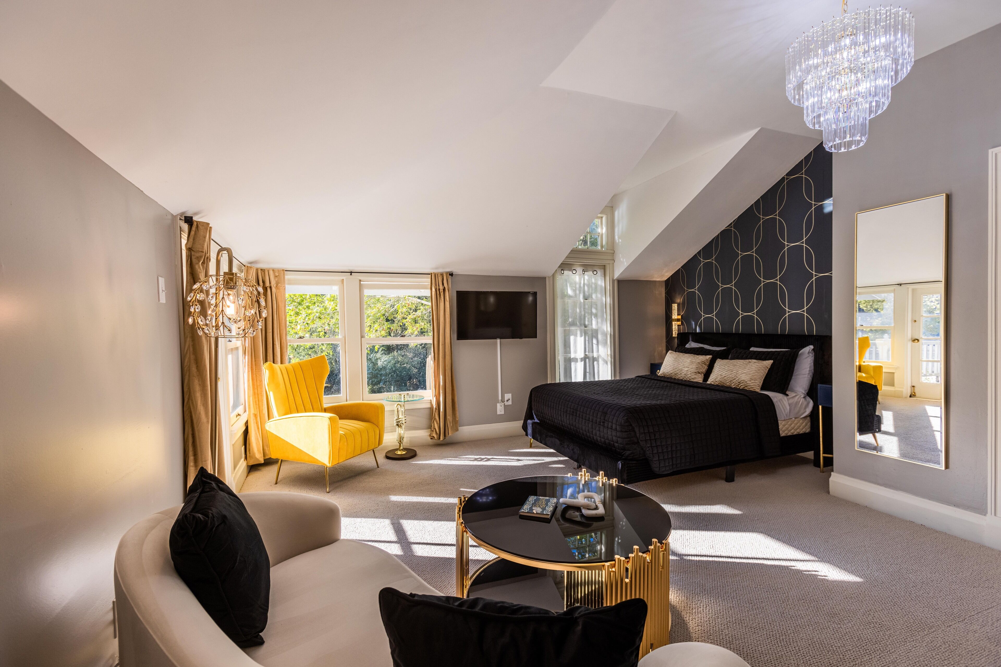 Une chambre à coucher moderne avec un lit, un canapé, une table basse et un téléviseur.