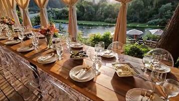 Mesa de comedor lista para una comida, con vistas a un lago y follaje.