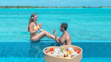 Guests can enjoy a refreshing dip in the pool overlooking the serene sea and lush shoreline.