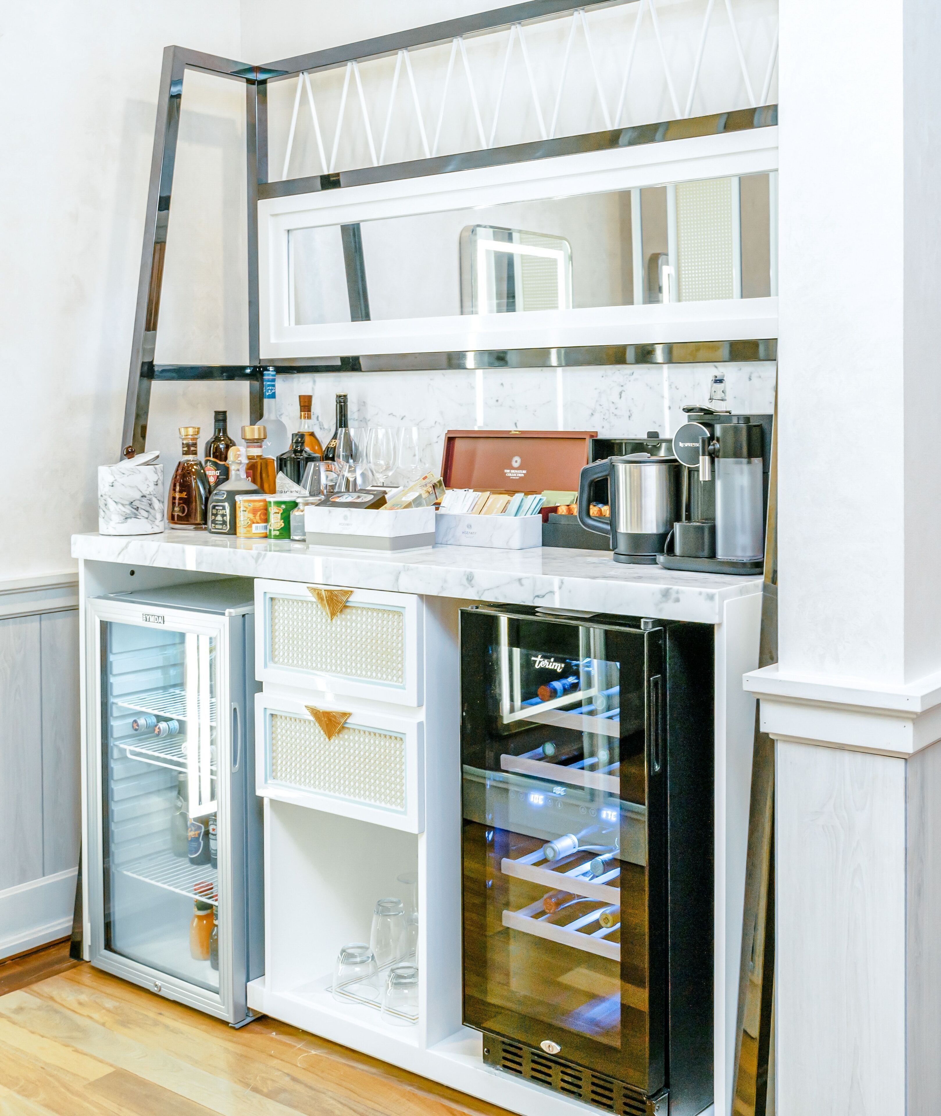 Una cocina compacta con refrigerador, microondas y cafetera.