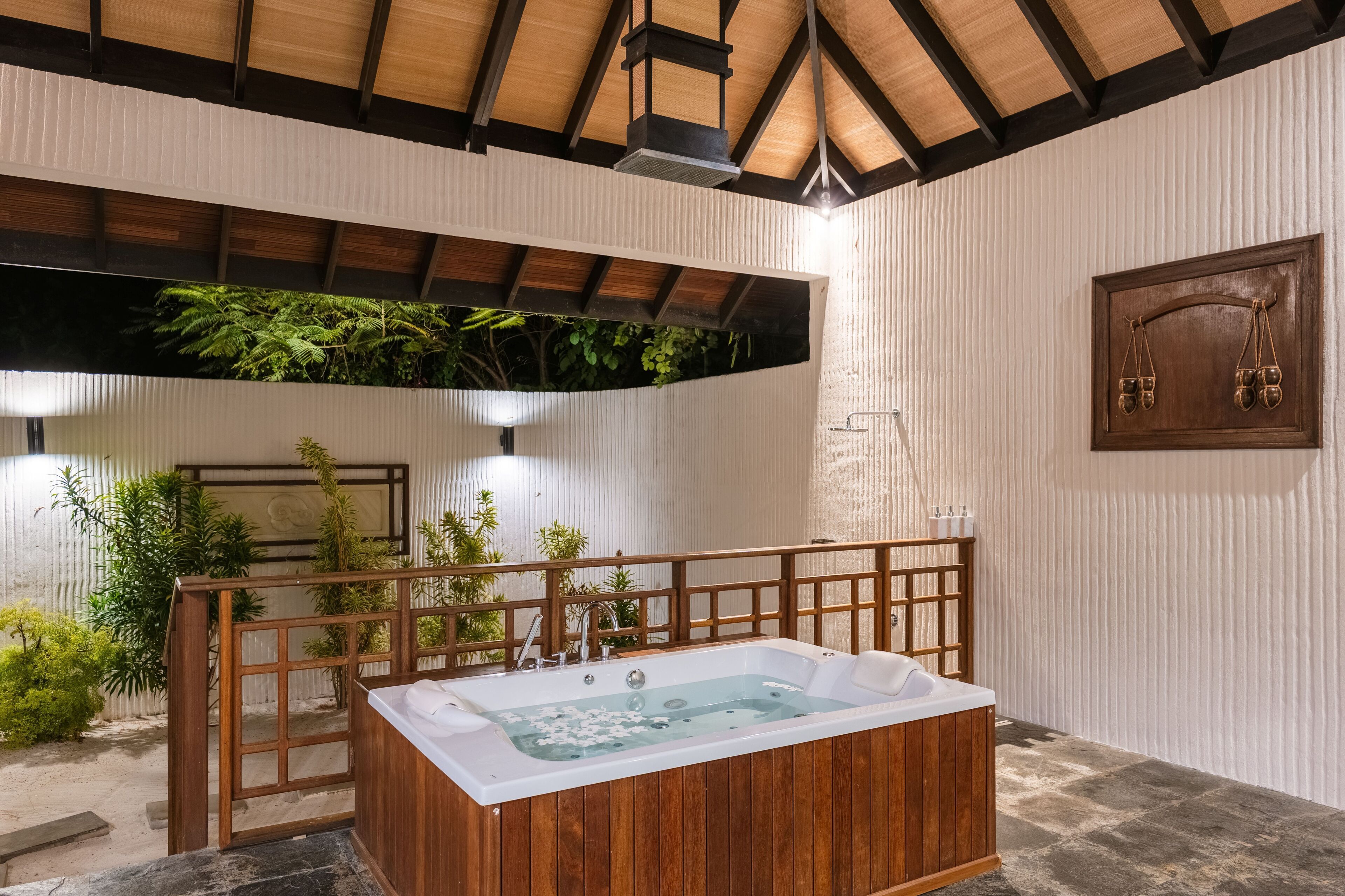 A spa area with a wooden bathtub, a wooden deck, and a wall-mounted scale.