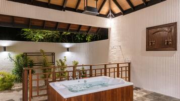A spa area with a wooden bathtub, a wooden deck, and a wall-mounted scale.