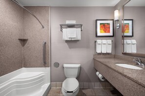 A modern bathroom with a bathtub, toilet, and sink.
