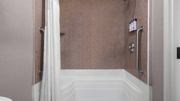 A modern bathroom with a shower, grab bars, and a toilet.