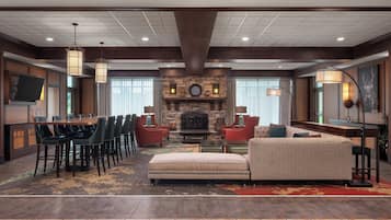 A spacious lobby with a fireplace, a dining area, and comfortable seating.