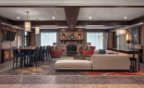 A spacious lobby with a fireplace, a dining area, and comfortable seating. - Holiday Inn Stevens Point - Convention Ctr by IHG (Stevens Point)