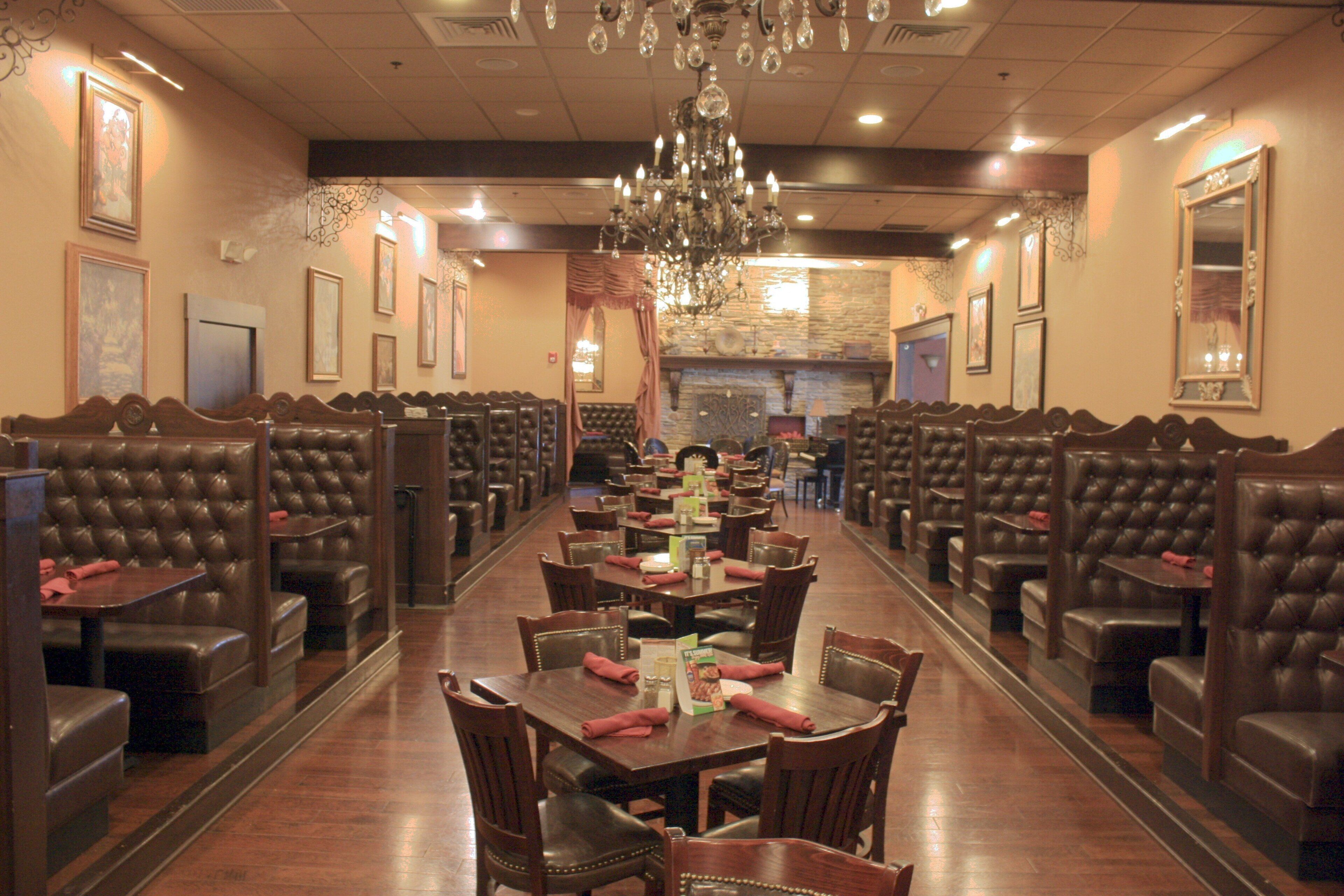 A restaurant with booth seating and a long table in the center.