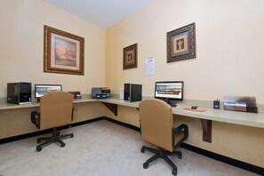 A conference room with two office chairs, a long table, and three desktop computers. - Holiday Inn Express & Suites Abilene by IHG (Abilene)