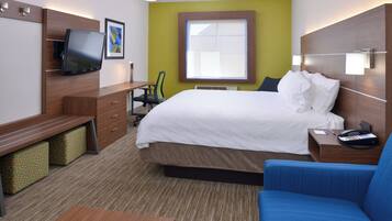 Una habitación de hotel con una cama, un escritorio, una silla, un televisor y una ventana.