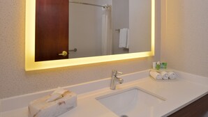 A bathroom with a white sink, a mirror with a lighted frame, and a towel rack with towels. - Holiday Inn Express & Suites Abilene by IHG (Abilene)
