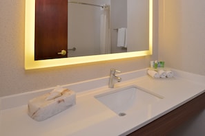A bathroom with a white sink, a mirror with a lighted frame, and a towel rack with towels. - Holiday Inn Express & Suites Abilene by IHG (Abilene)