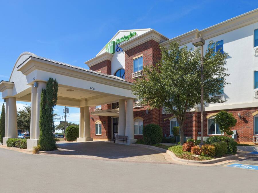 A Holiday Inn Express hotel with a covered entrance, a brick facade, and a landscaped front yard.