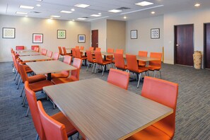 A conference room with multiple tables and chairs, carpeted flooring, and framed artwork on the walls. - Holiday Inn Express & Suites Abilene by IHG (Abilene)