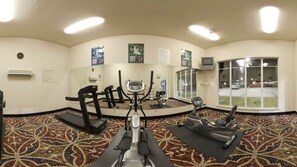 Un centre de remise en forme équipé de tapis de course, de vélos d’appartement et d’autres appareils d’exercice.