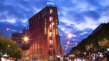 A hotel with a prominent 'HOTEL' sign at the top, multiple balconies, and a classic architectural style.