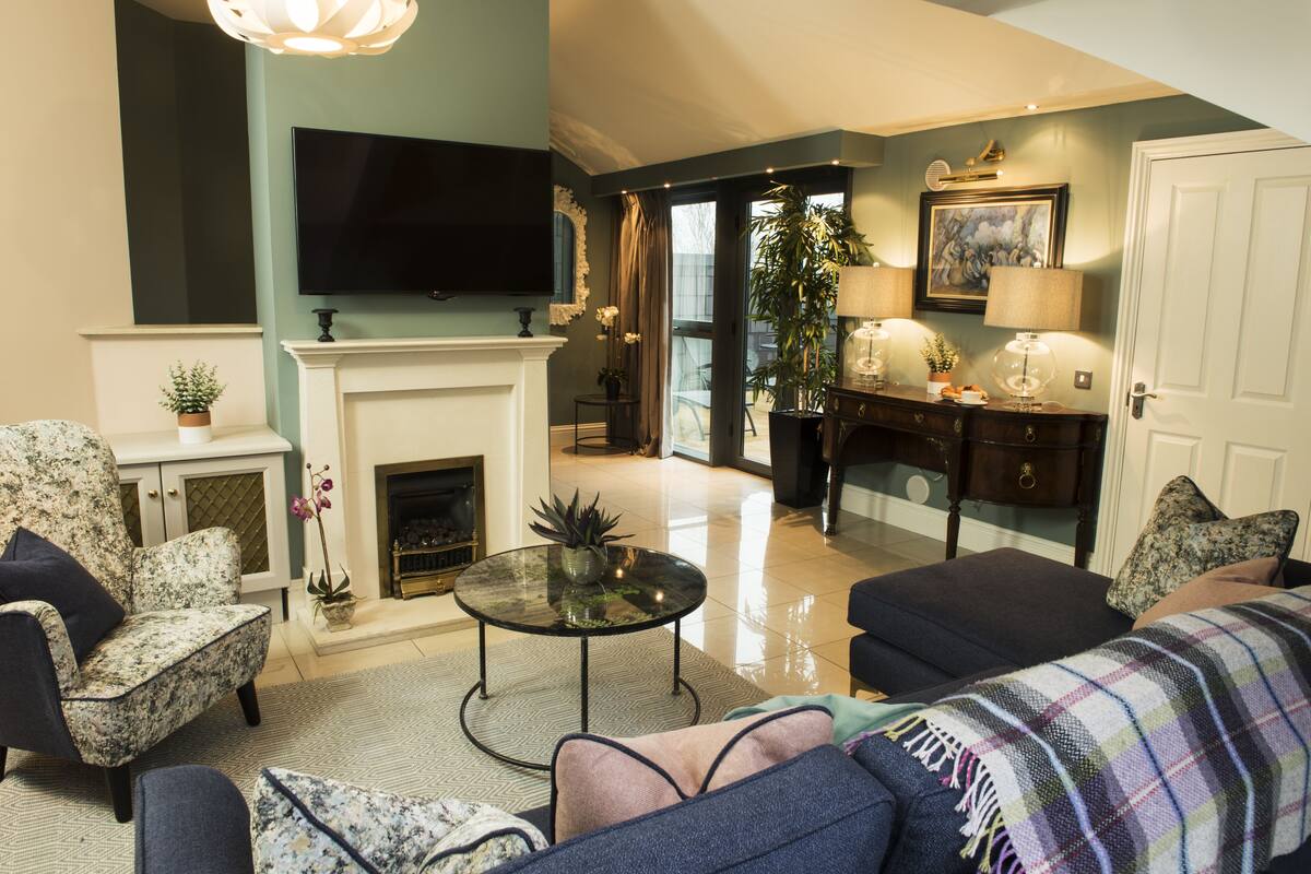 A living room with a fireplace, sofa, and television.