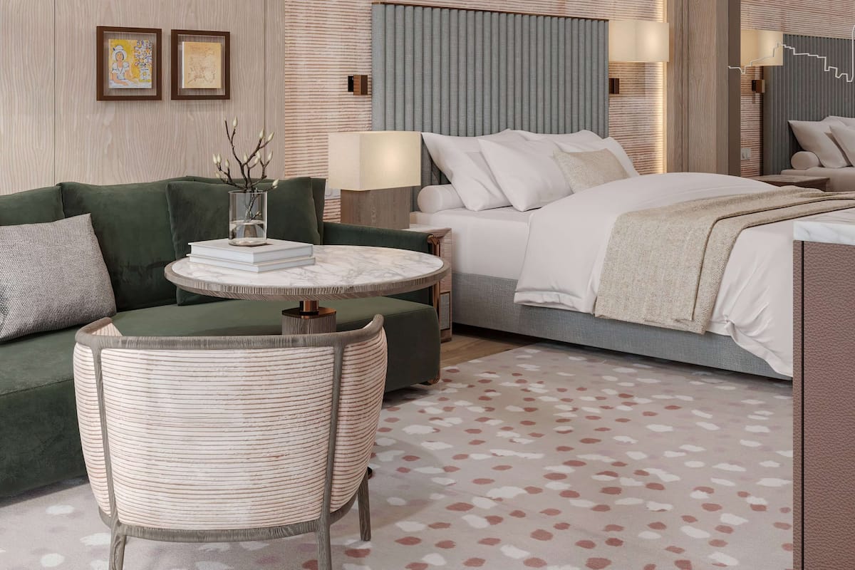 Ein modernes Hotelzimmer mit einem grünen Sofa, einem runden Tisch, einem Bett mit weißer Bettwäsche und einem gemusterten Teppich.