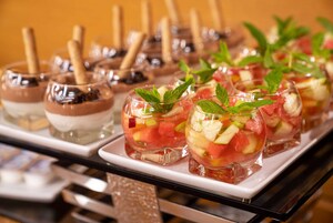 Een dienblad met dessertglazen, diverse toppings en muntblaadjes.