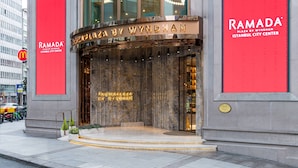 La entrada del Ramada Plaza by Wyndham en Estambul, con fachada de mármol y señalización iluminada.