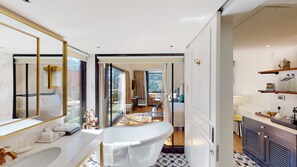 A modern bathroom with a freestanding bathtub, a large mirror, and a vanity with a marble countertop. - Radisson Hotel Shimla (Shimla)