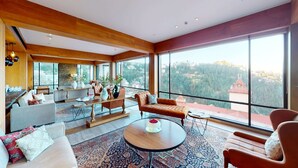 A spacious living area with a large window offering a view of a mountainous landscape.
