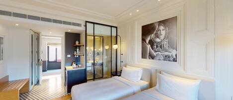 Habitación de hotel con una cama grande, zona de estar, ducha y baño.