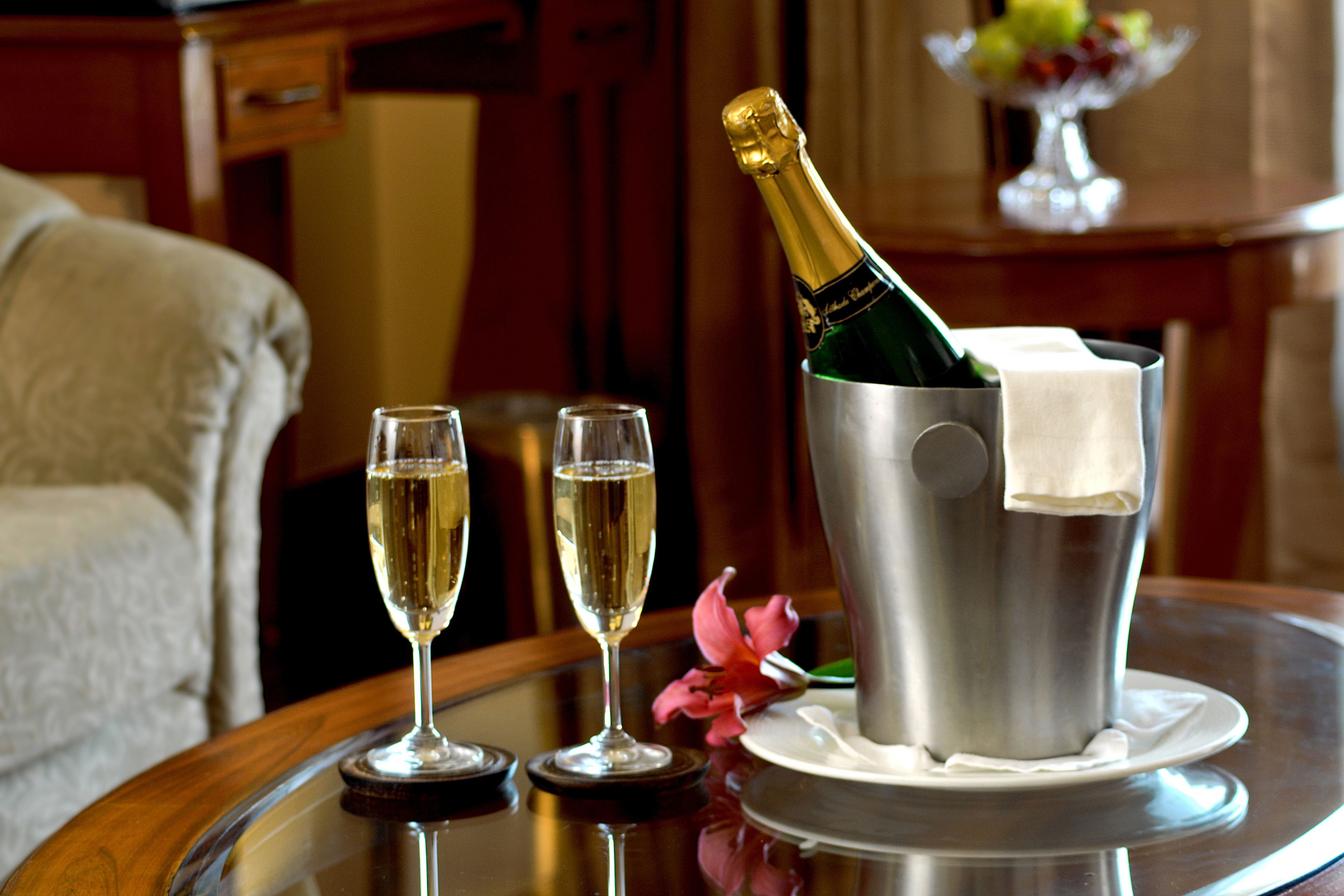A table with two champagne flutes and a champagne bottle in a bucket.