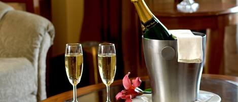 A table with two champagne flutes and a champagne bottle in a bucket.