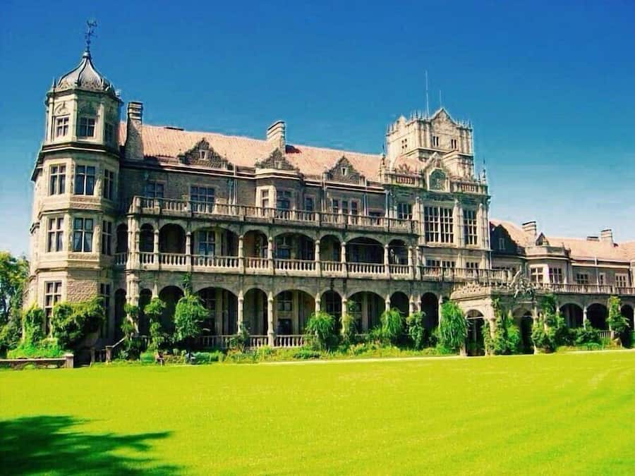 A large, historic building with multiple levels, arched windows, and a central courtyard.