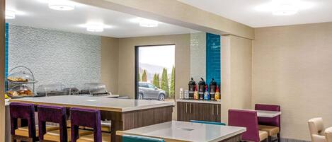 Un moderno hall de hotel con una zona de bar, asientos y vistas al exterior.