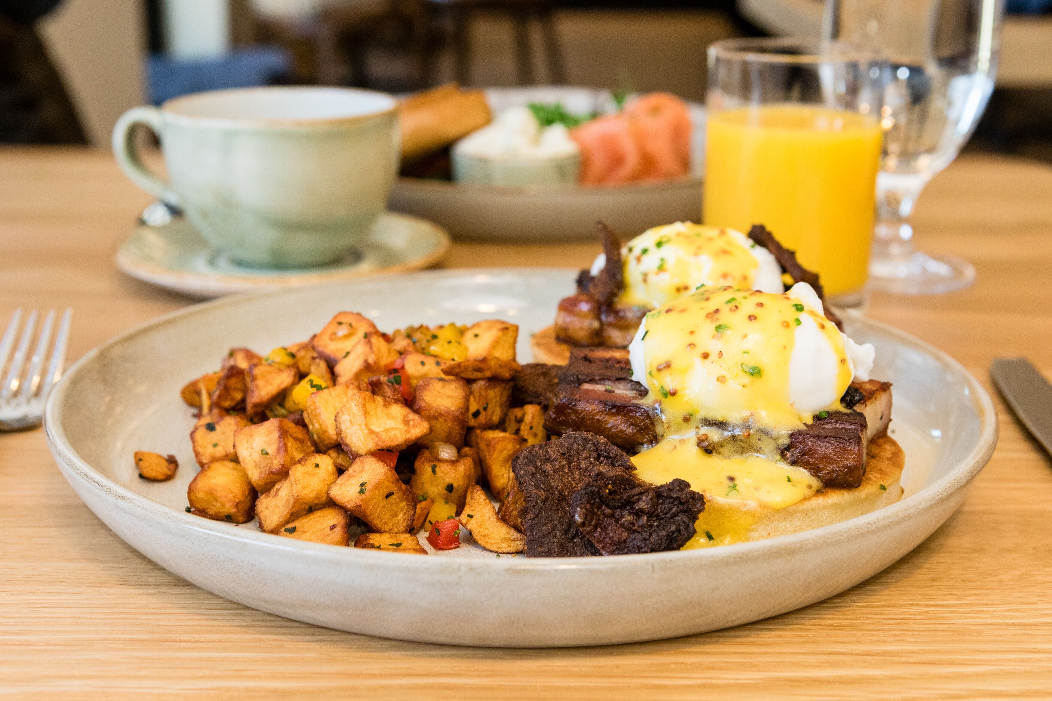 A breakfast plate with eggs, potatoes, and meat.